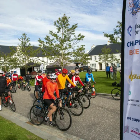 Chapleton charity cycle ride in Aberdeenshire to support North East Sensory Services. Several cyclists on the start line with residential houses in the background.