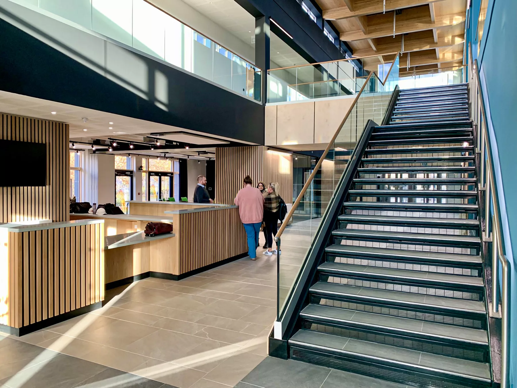 Internal photograph of the Rural and Veterinary Innovation Centre, showing people at reception desk on left-hand side and stairs up to first floor level on right.
