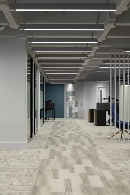 A long view down the office refurbishment for Changeworks, showing mixed flooring, meeting rooms and staff lockers. Defurbishment style feature ceiling with exposed beams and services