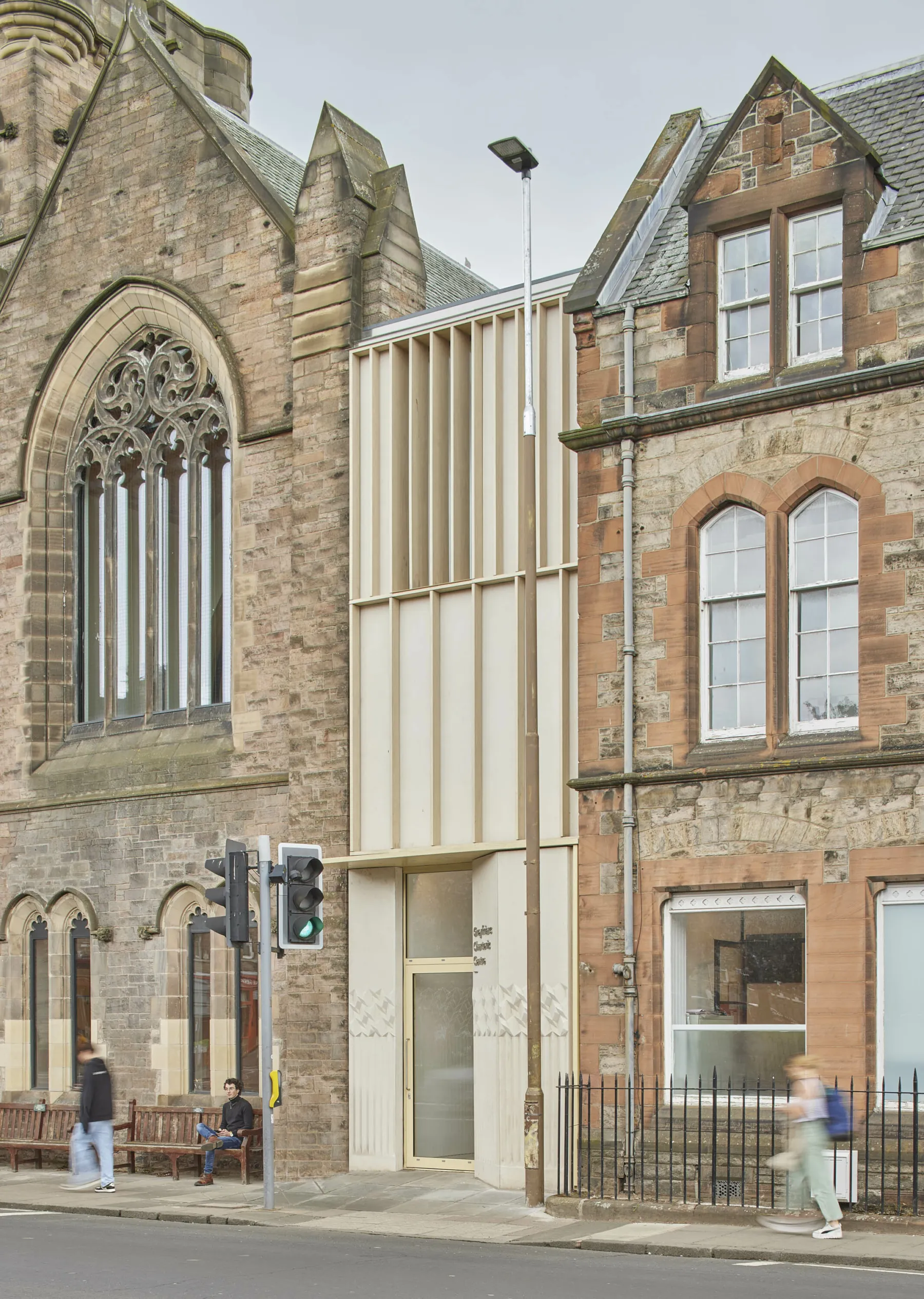 Exterior view of the Greyfriars Charteris Centre showing a section of the former sandstone church and the three storey sandstone office building. In between is the new extension in timber and terrazzo cladding.