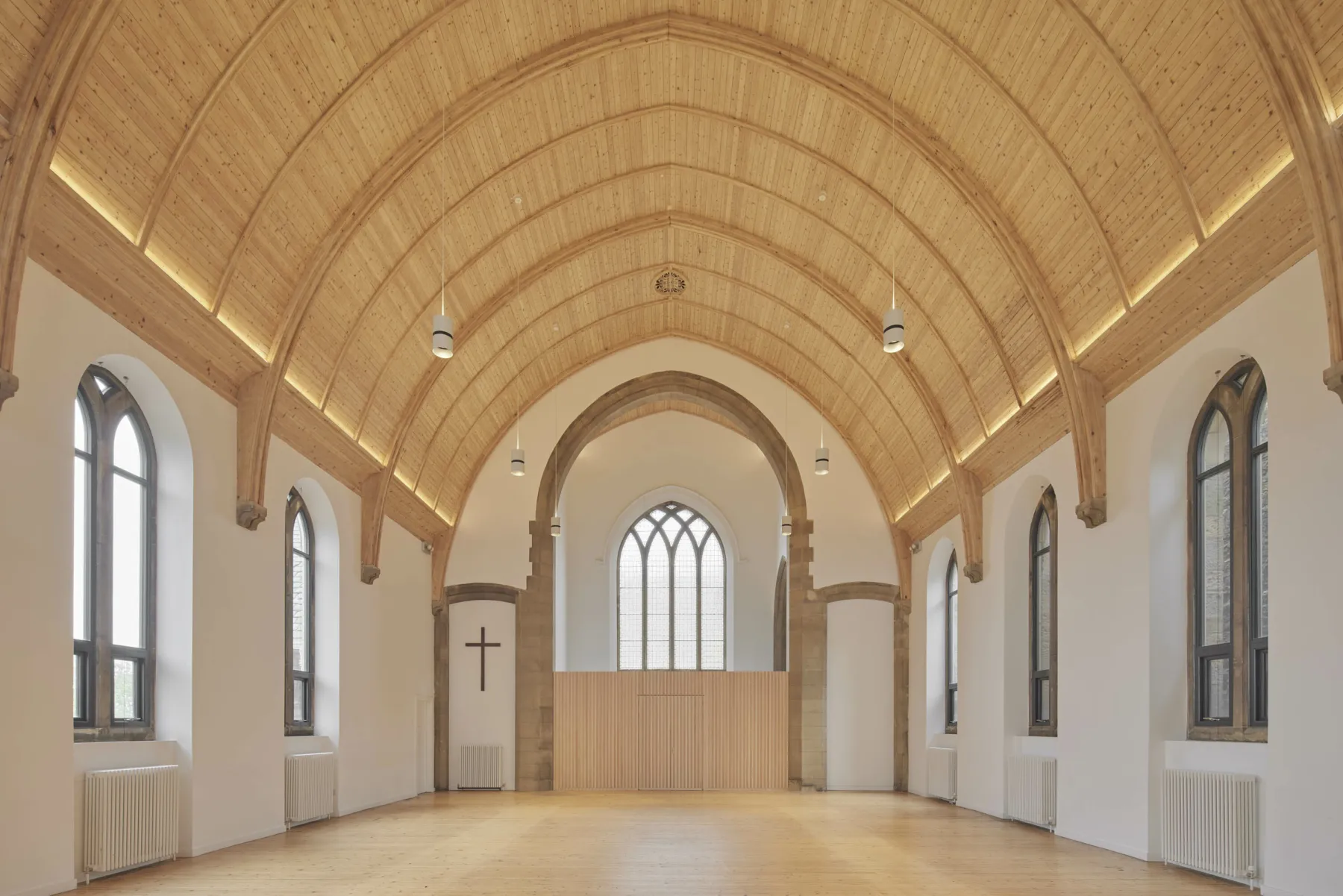 The nave at the restored and converted former church at the Greyfriars Charteris Centre, Edinburgh. The timbered ceiling is lighter, the floor has been polished and new apse screen erected. It is a bright space with better light from new unleaded, windows.