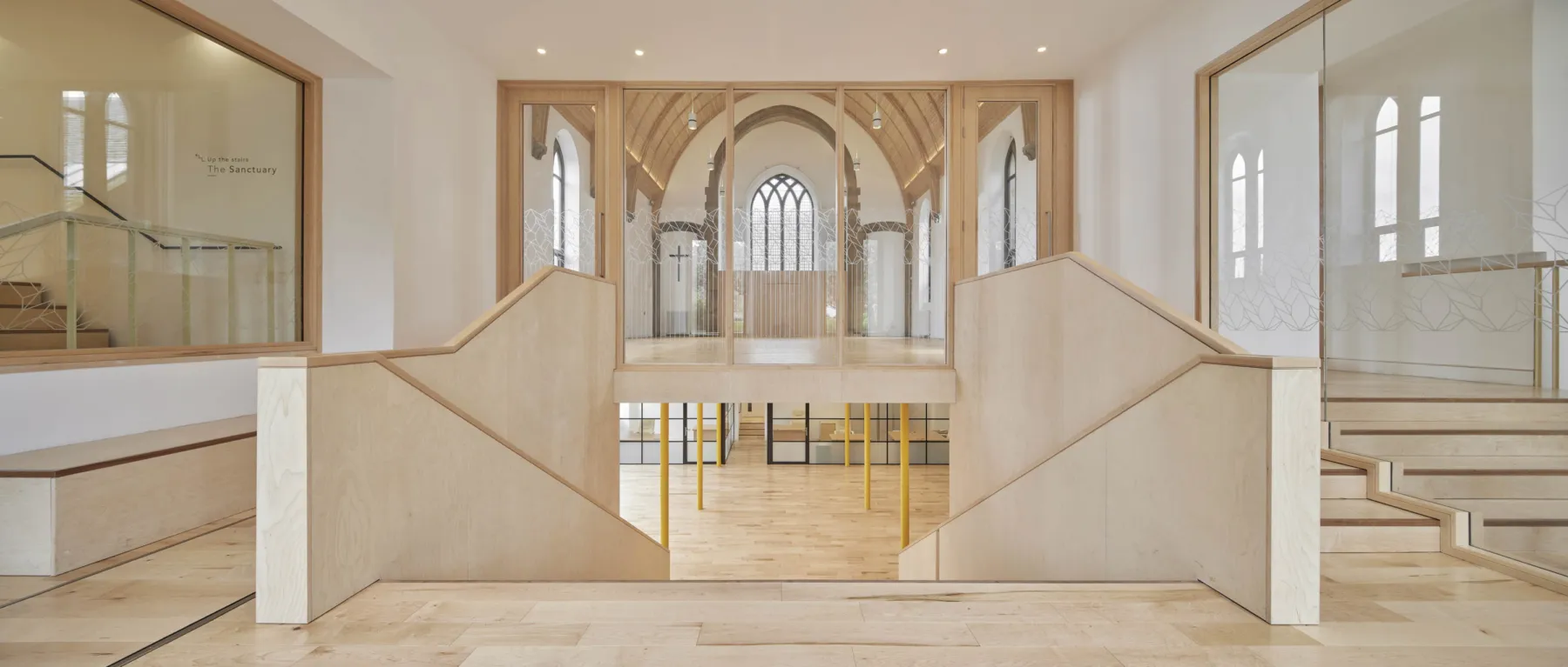 Interior view of the Greyfriars Charteris Centre, Edinburgh, a refurbished and restored church with contemporary extension. Looking though large glass doors to the nave and down the stairs to the undercroft.