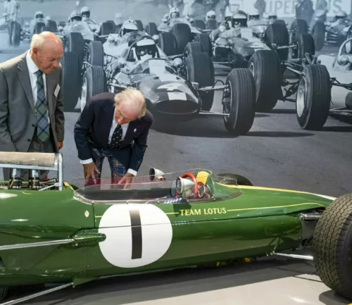 Sir Jackie Stewart examines a green, vintage formula one Lotus  racing car at the opening of the Jim Clark Motorsport Museum, Duns, Scotland.
