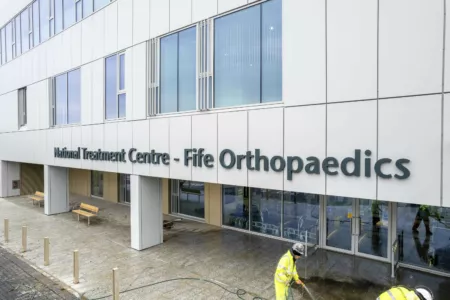 Entrance area at the National Treatment Centre - Fife Orthopaedics. Staff in high vis clothing are washing the forecourt.