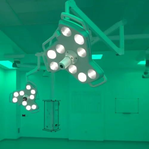 Inside a new operating theatre at the National Treatment Centre - Fife Orthopaedics, Kirkcaldy, Scotland. Theatre lighting and screens. The theatre is flooded with green light. There is no operating table or other equipment.