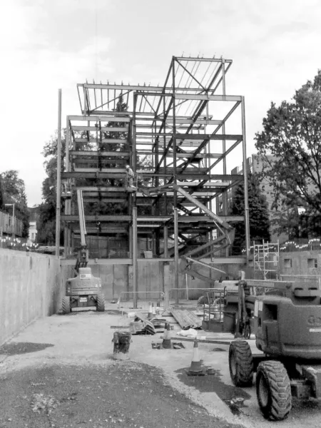Construction image of student residential block at the University of Edinburgh Pollock Halls. The foundations and steel framework of the new 5 storey block are in place. Digger in the foreground.